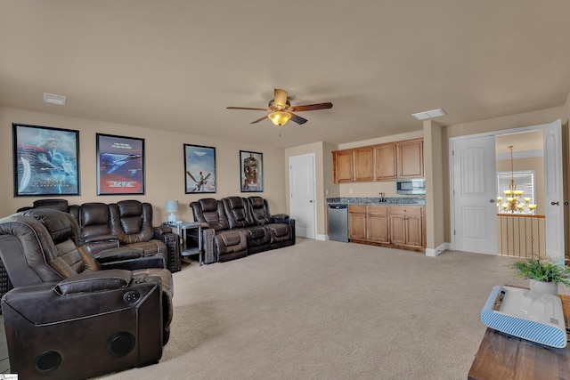 living area featuring light carpet, ceiling fan with notable chandelier, visible vents, and baseboards