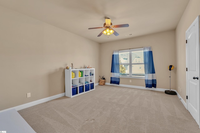 recreation room featuring light carpet, visible vents, a ceiling fan, and baseboards