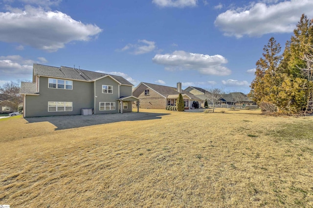 back of house with a residential view and a yard