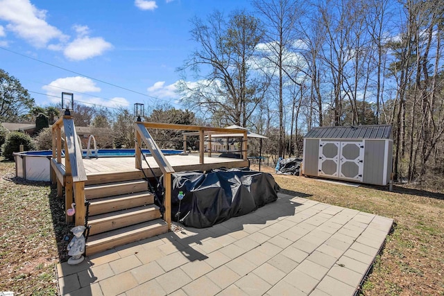 view of patio / terrace featuring a storage shed, an outdoor pool, and an outbuilding