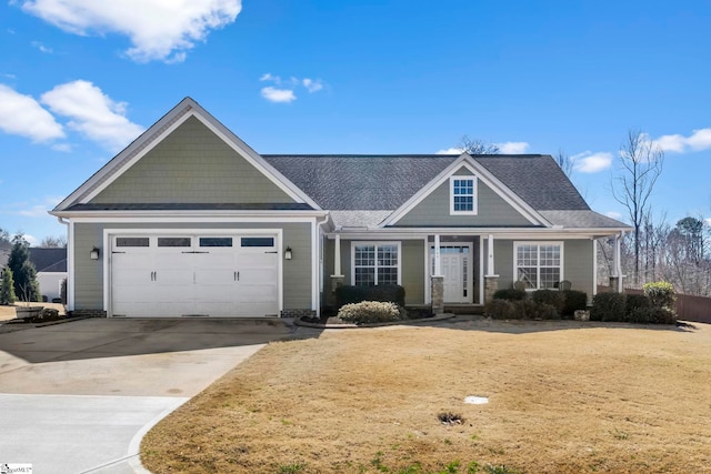 view of front facade featuring a garage, a shingled roof, a front lawn, and concrete driveway