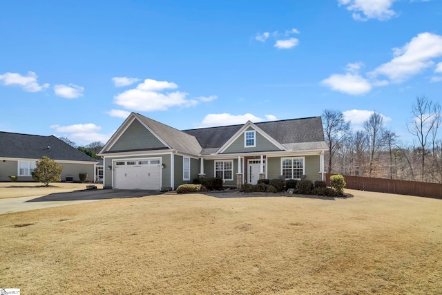 view of front of home featuring a garage, driveway, a front yard, and fence