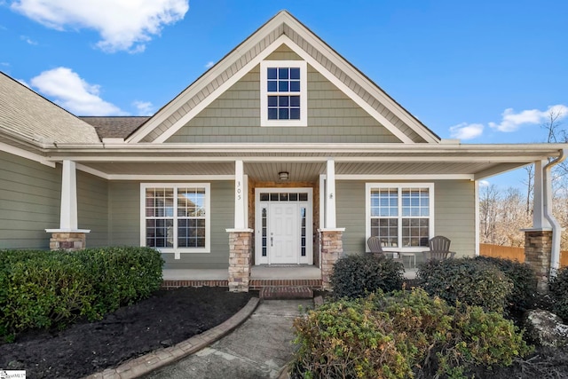 view of front of home with a porch and a shingled roof