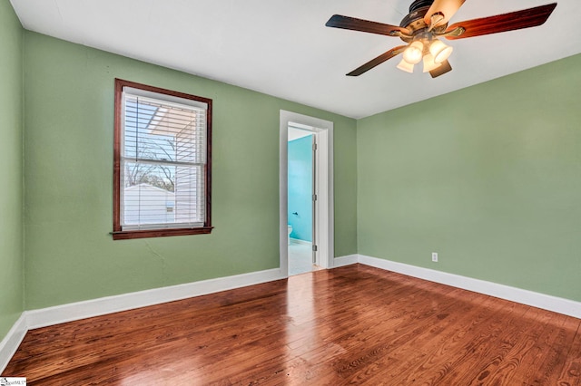 spare room with a ceiling fan, baseboards, and wood finished floors