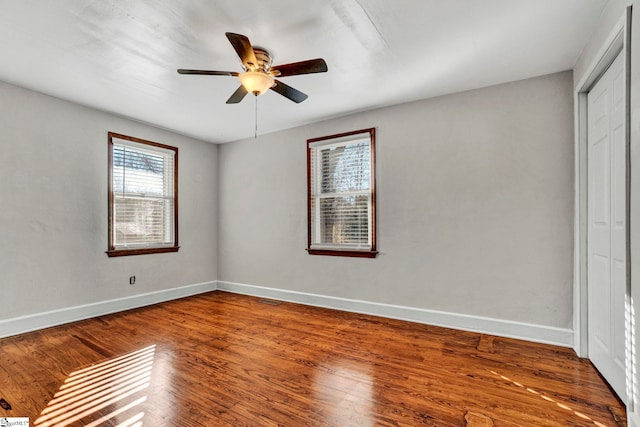 unfurnished room featuring a ceiling fan, visible vents, baseboards, and wood finished floors