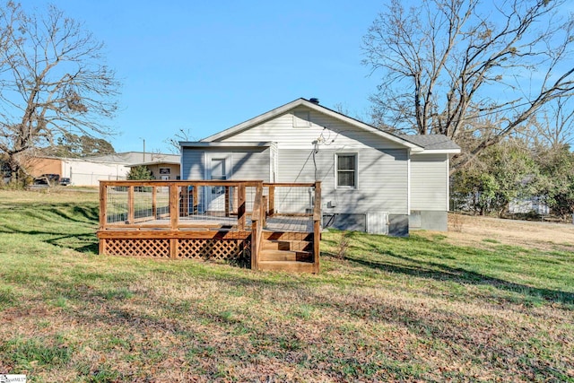 rear view of property featuring a deck and a yard