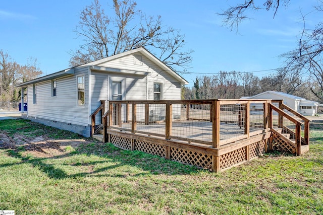 back of property with a deck, crawl space, and a lawn