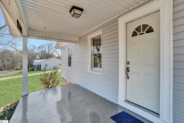 view of exterior entry featuring a yard