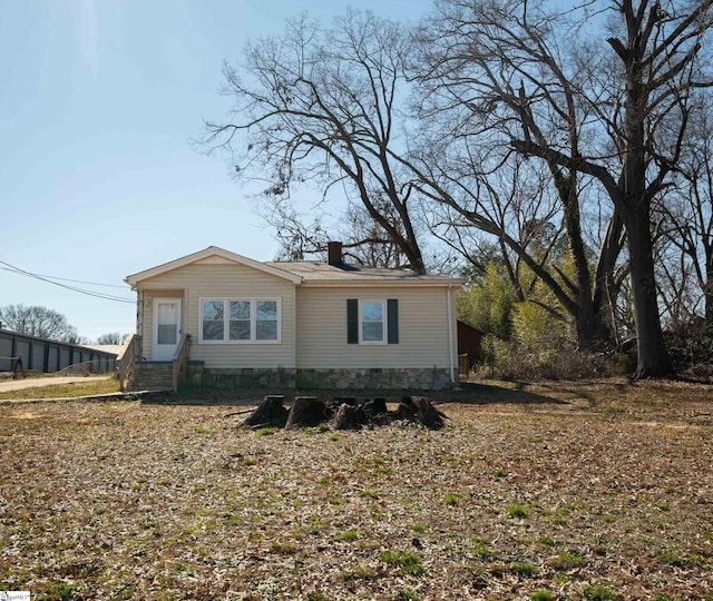 view of front of house with entry steps, crawl space, and a chimney