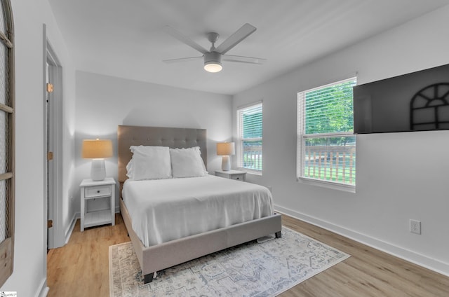 bedroom featuring light wood-type flooring, a ceiling fan, and baseboards