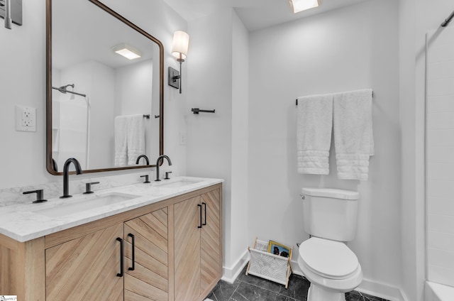 bathroom featuring toilet, double vanity, a shower, and a sink