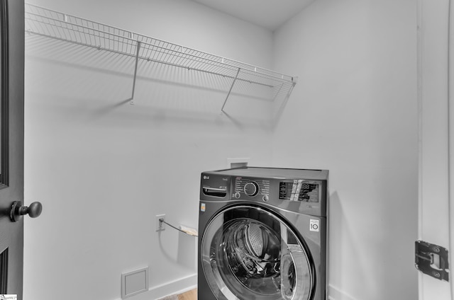 clothes washing area featuring washer / clothes dryer, baseboards, and laundry area