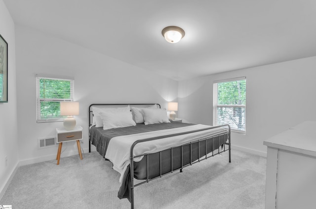 bedroom featuring light carpet, visible vents, and baseboards