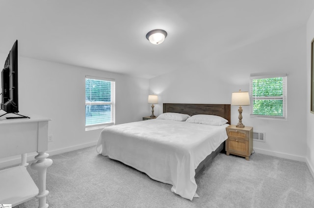 bedroom with light carpet, visible vents, and baseboards