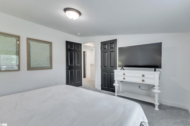 bedroom with baseboards and light colored carpet