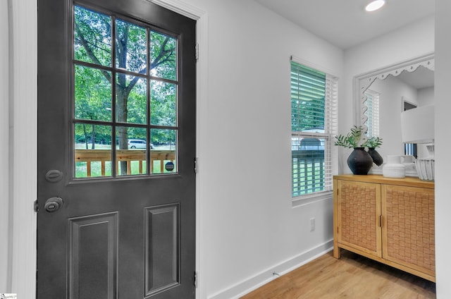 doorway to outside featuring light wood-style flooring and baseboards