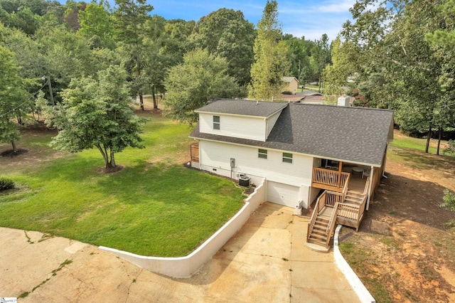 exterior space with a shingled roof, concrete driveway, central AC unit, a front lawn, and stairs