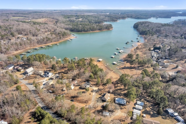 drone / aerial view featuring a water view and a wooded view