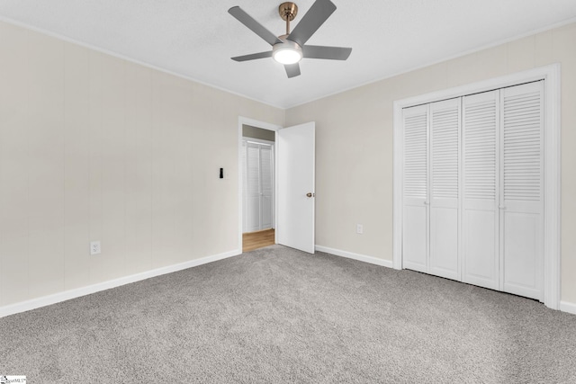 unfurnished bedroom with a closet, carpet flooring, ceiling fan, and baseboards