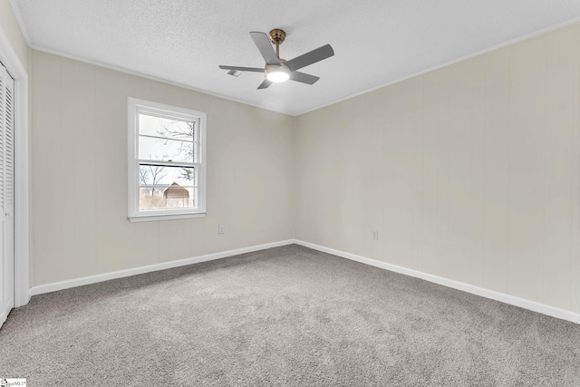 unfurnished bedroom featuring carpet, a closet, a ceiling fan, a textured ceiling, and baseboards