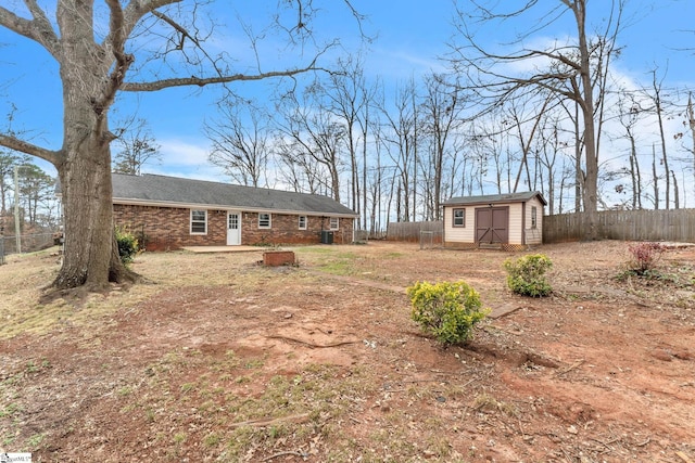 view of yard with a storage shed, an outdoor structure, fence, and central air condition unit