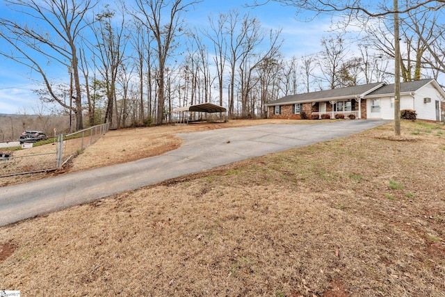 view of front of property with aphalt driveway, a front lawn, fence, and brick siding