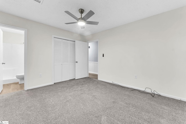 unfurnished bedroom featuring carpet, a closet, a textured ceiling, and baseboards