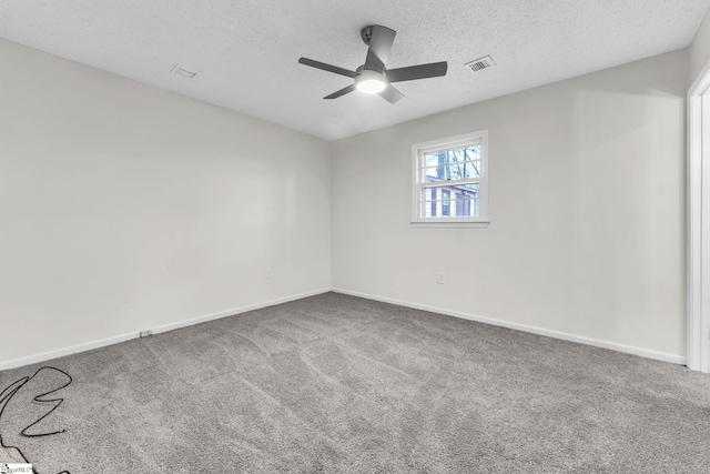 carpeted spare room with a textured ceiling, a ceiling fan, visible vents, and baseboards