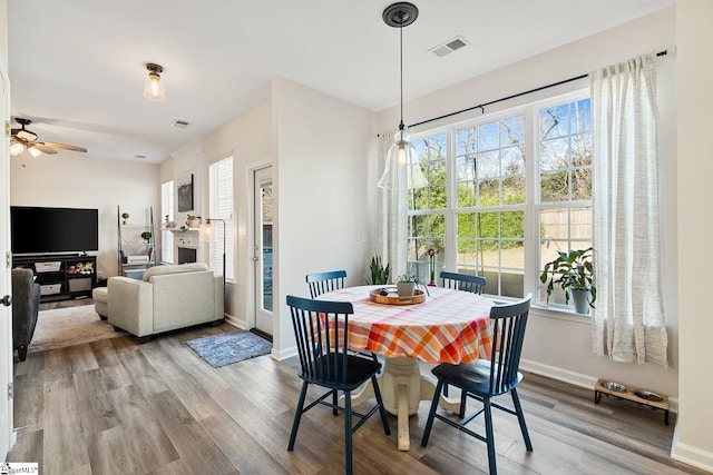 dining room with visible vents, ceiling fan, light wood-style flooring, and baseboards