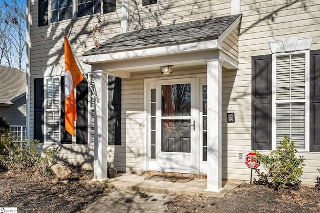 property entrance with a shingled roof