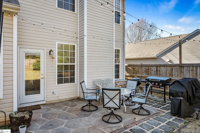 view of patio / terrace featuring outdoor dining area, fence, and a grill