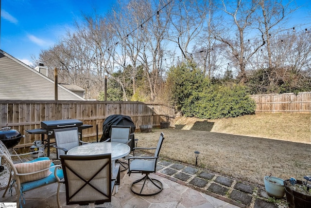 view of patio featuring outdoor dining area, a fenced backyard, and area for grilling