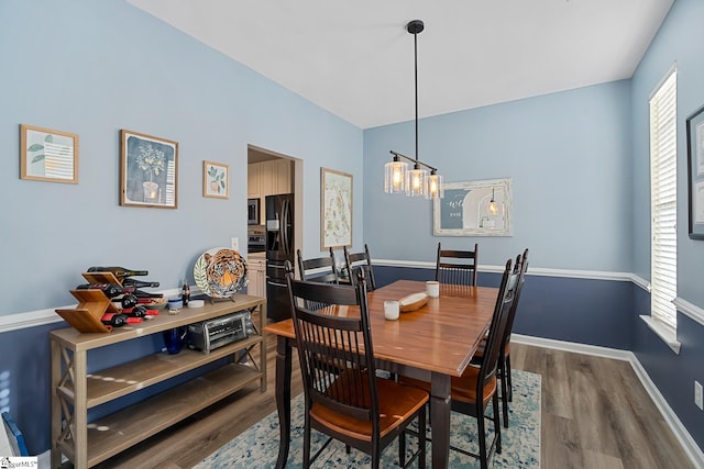 dining room with an inviting chandelier, baseboards, and wood finished floors