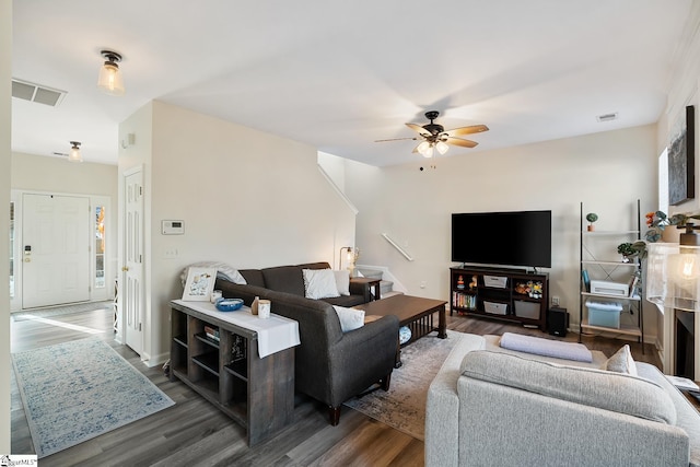 living area with dark wood-style floors, visible vents, and a ceiling fan