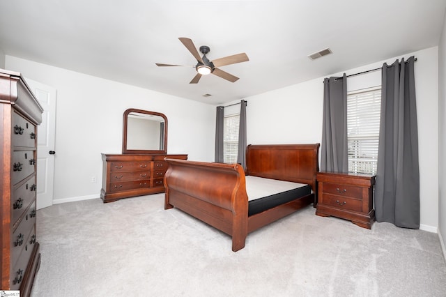 bedroom with light carpet, multiple windows, visible vents, and baseboards