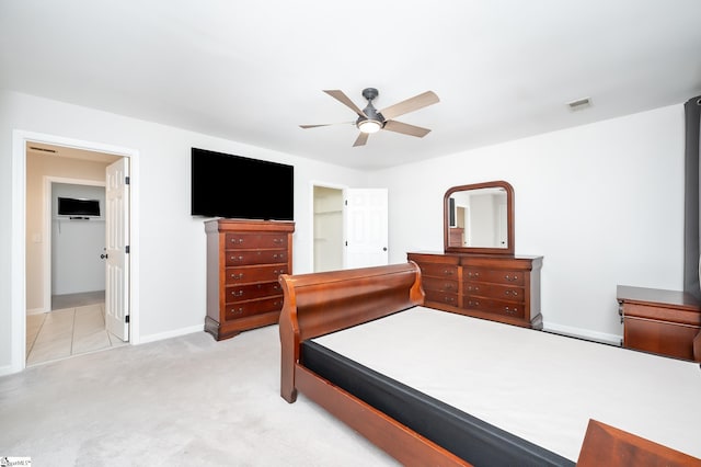 bedroom featuring baseboards, visible vents, a ceiling fan, and light colored carpet