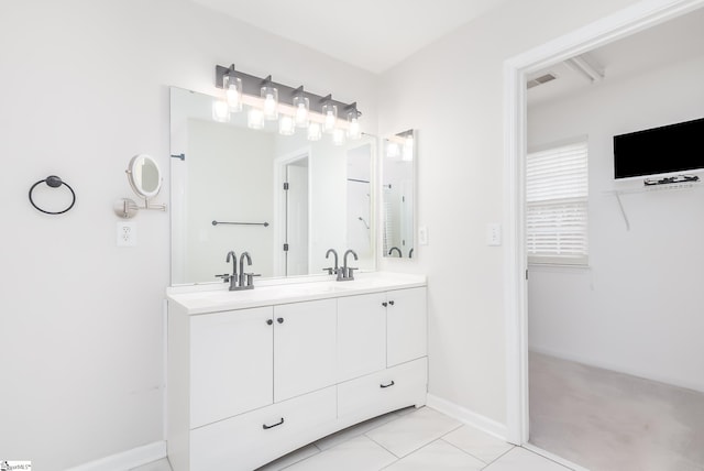 bathroom featuring double vanity, baseboards, visible vents, a spacious closet, and a sink