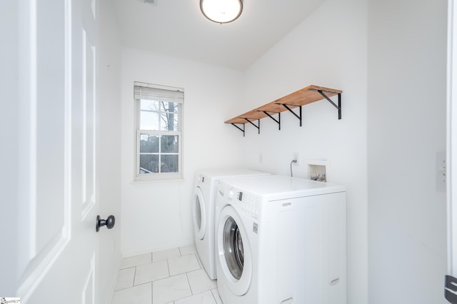 laundry room featuring laundry area, light tile patterned flooring, washer and clothes dryer, and baseboards