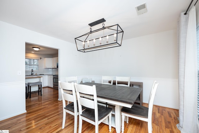 dining room with visible vents, a chandelier, and dark wood-type flooring