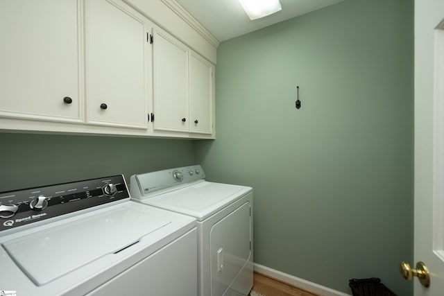 laundry room with cabinet space, washing machine and dryer, and baseboards