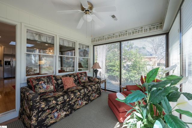 sunroom with a ceiling fan and visible vents