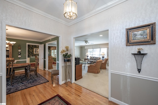 interior space featuring baseboards, ornamental molding, a notable chandelier, and wood finished floors