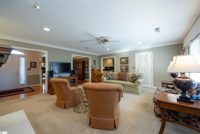 living area with visible vents, crown molding, and recessed lighting