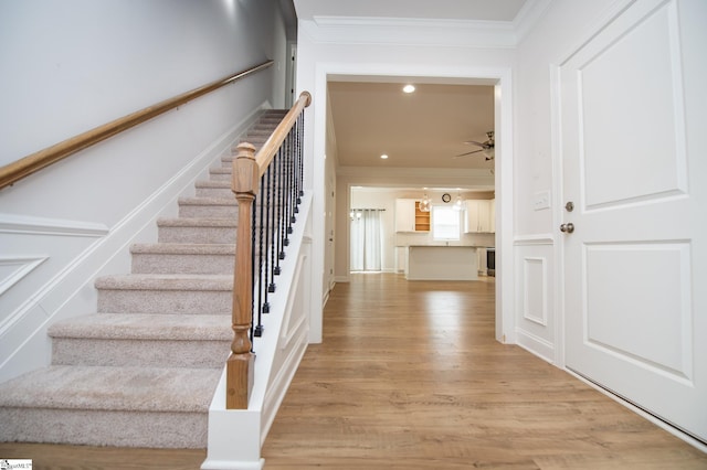 foyer with light wood finished floors, ceiling fan, stairs, crown molding, and recessed lighting