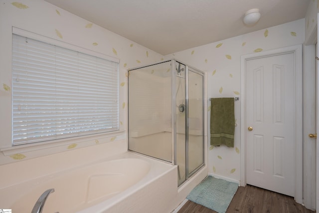 full bath featuring wood finished floors, a shower stall, and wallpapered walls