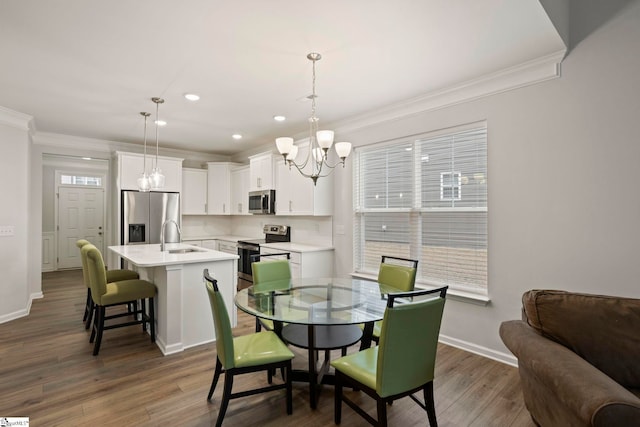 dining room with baseboards, ornamental molding, dark wood-style flooring, a notable chandelier, and recessed lighting