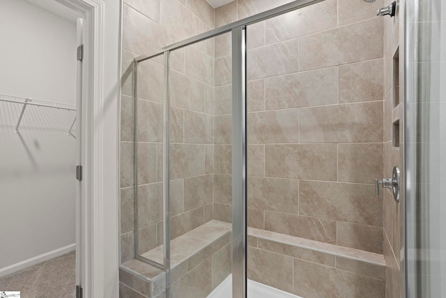 full bath featuring a stall shower and a spacious closet