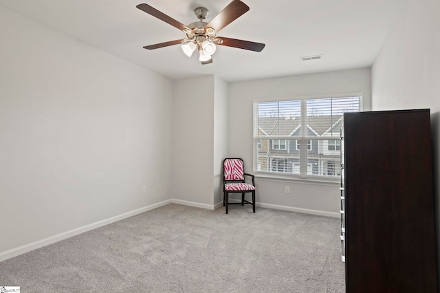 unfurnished room featuring a ceiling fan, light colored carpet, visible vents, and baseboards