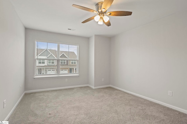 unfurnished room featuring light carpet, ceiling fan, visible vents, and baseboards