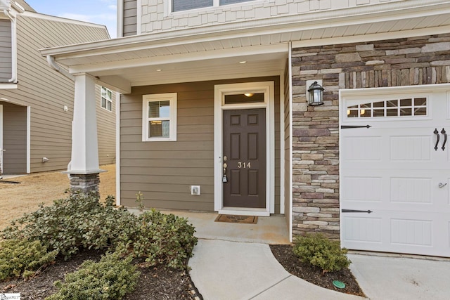 doorway to property featuring stone siding and covered porch